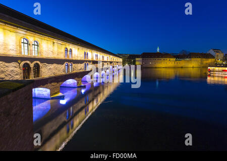 Barrage Vauban illuminée au crépuscule se reflétant dans les eaux de l'Ill, Alsace France Banque D'Images