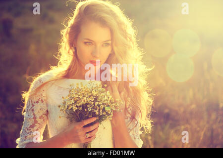 Belle jeune mariée en plein air au coucher du soleil Banque D'Images