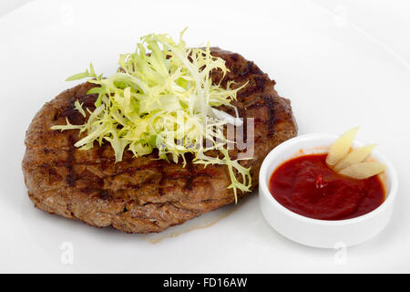 Des portions de juteux épais succulent steak poêlé, servi avec une sauce tomate sur une plaque blanche Banque D'Images