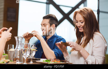 Happy friends taking picture de nourriture au restaurant Banque D'Images