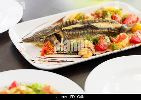 Esturgeon jaune cuite au four avec les fruits et légumes verts, soft focus sélectif. Banque D'Images