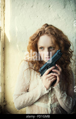 Redhead woman holding a gun Banque D'Images