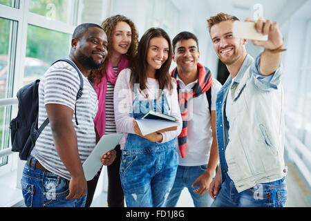 Les étudiants faisant leur amical en selfies corridor college Banque D'Images