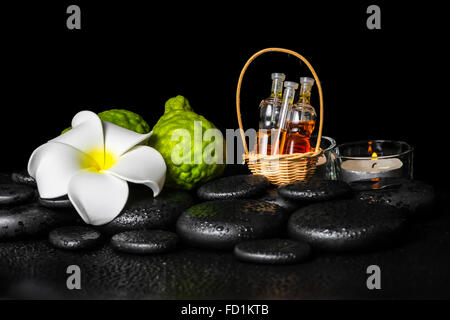 L'établissement spa aromatique de bergamote fruits, bougies, plumeria flower et bouteilles d'huile essentielle sur le zen stones, gros plan Banque D'Images