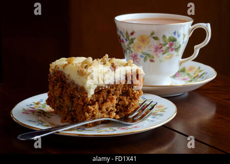 Tasse de thé et soucoupe sur tranche de gâteau de carotte sur la correspondance avec la plaque de la Chine Banque D'Images