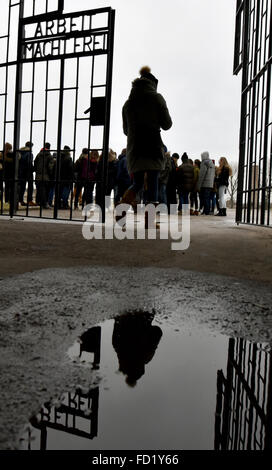 Oranienburg, Allemagne. 17 Jan, 2016. Visiteurs franchissent la porte de l'ancien camp de concentration de Sachsenhausen, qui portent les mots "Arbeit macht frei" (le travail vous met gratuitement), à Oranienburg, Allemagne, 17 janvier 2016. Les victimes du national-socialisme ont commémoré aujourd'hui à de nombreux endroits à l'échelle nationale. Photo : BERND SETTNIK/dpa/Alamy Live News Banque D'Images