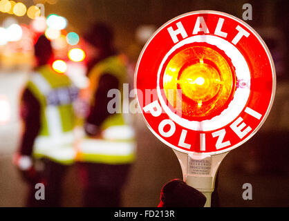 ILLUSTRATION - un agent de police est titulaire d'une police rouge stop qui se lit 'Stop' de la police - au cours d'un contrôle sur place de la police de la circulation à Hambourg, Allemagne, 26 janvier 2016. La force de la police de Hambourg a lancé une opération d'envergure contre le cambriolage en effectuant des contrôles sur place également sur la circulation. Photo : Daniel Bockwoldt/dpa Banque D'Images