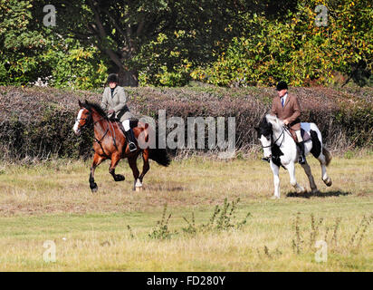 Les coureurs masculins et féminins galoper dans un champ Banque D'Images