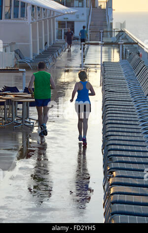 Tôt le matin, les coureurs de l'exercice avec soin le long circuit de course croisière dédié entre les chaises longues après la pluie tombée pendant la nuit Banque D'Images