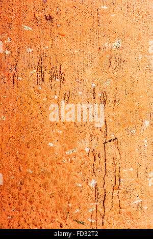 Arrière-plan créatif vieux mur de béton peinture peinture orange, taches les tâches d'eau, des fissures et des rayures. La formation rocheuse surface. Gr Banque D'Images