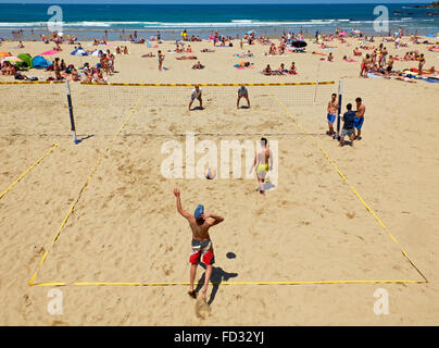 Youngs mens jouer au volley-ball dans la plage de Zurriola, San Sebastian, Guipuzcoa. Espagne Banque D'Images