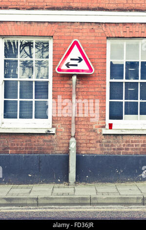 Un panneau d'avertissement pour un 2 way street contre un mur de brique rouge building Banque D'Images