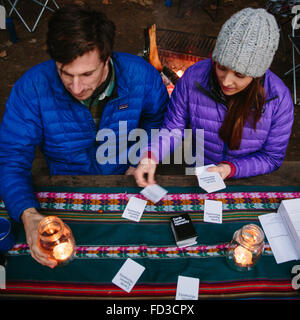 Un jeune couple jouer un jeu de carte camping à Big Sur, en Californie. Banque D'Images