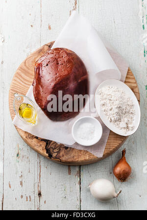 Foie cru avec des ingrédients sur la table en bois bleu Banque D'Images