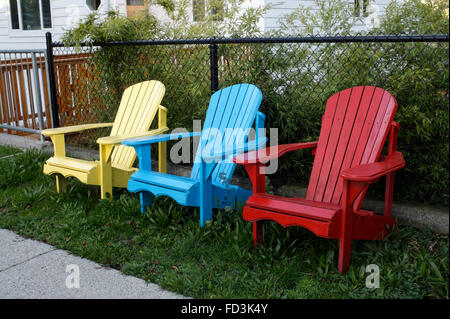 Trois chaises Adirondack en bois peint dans les couleurs primaires rouge, jaune et rouge Banque D'Images