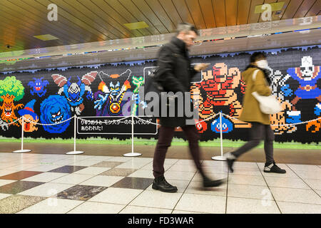 Les piétons devant une immense murale Dragon Quest fait en blocs Lego Le 27 janvier 2016 à Tokyo, Japon. La fresque fait partie d'une promotion à la gare de Shinjuku pour fêter la sortie de nouveau le jeu Dragon Quest les constructeurs. La murale a été faite de 80 mètres avec 180 000 les blocs de Lego et les fans seront autorisés à supprimer des blocs à partir du 28 janvier pour révéler un secret derrière l'affiche. Certains blocs contiennent aussi des codes QR permettant aux fans d'accéder à des contenus exclusifs. © Rodrigo Reyes Marin/AFLO/Alamy Live News Banque D'Images