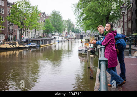 Jeune couple Caucasian apprécier la beauté d'Amsterdam, même s'il pleut Banque D'Images