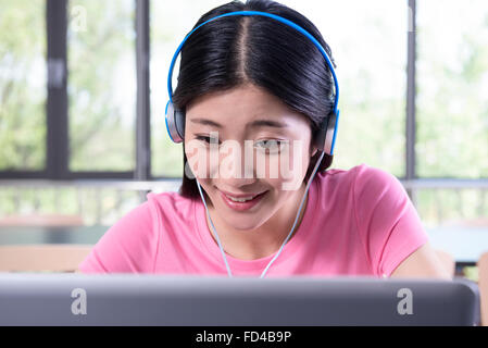 College student using laptop in library Banque D'Images