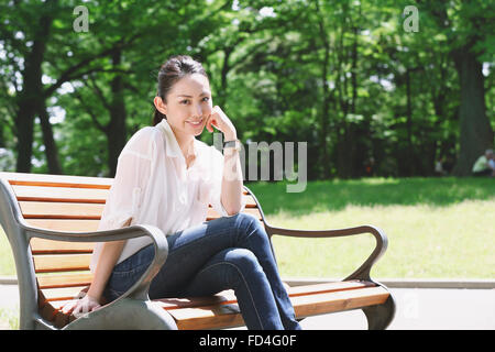 Jolie femme japonaise dans un parc de la ville Banque D'Images