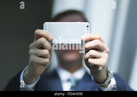 Caucasian businessman with phone in modern office Banque D'Images