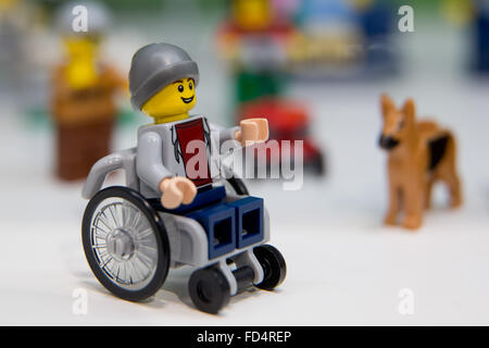 Nuremberg, Allemagne. 28 janvier, 2016. Lego une figure dans un fauteuil roulant peut être vu à côté d'un chien Lego sur le stand pour le fabricant danois Lego à la 67ème "International" peilwarenmesse Salon du Jouet à Nuremberg, Allemagne, 28 janvier 2016. Le plus grand salon du jouet continue jusqu'au 01 février 2016. Photo : DANIEL KARMANN/dpa/Alamy Live News Banque D'Images