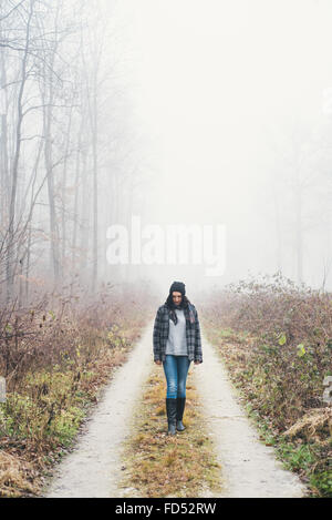 Femme ayant une promenade en forêt brumeuse Banque D'Images