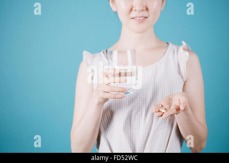 Japanese woman taking pills Banque D'Images