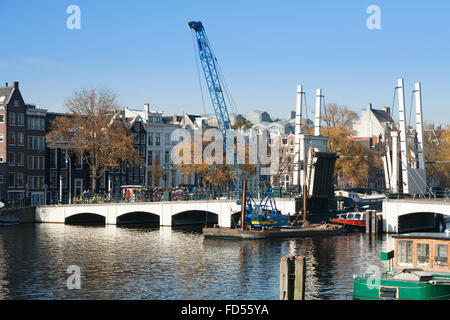 Bateau / péniche passe sous le Magere Brug (pont "Magere Brug") en Néerlandais Amsterdam, Pays-Bas, Hollande. Banque D'Images