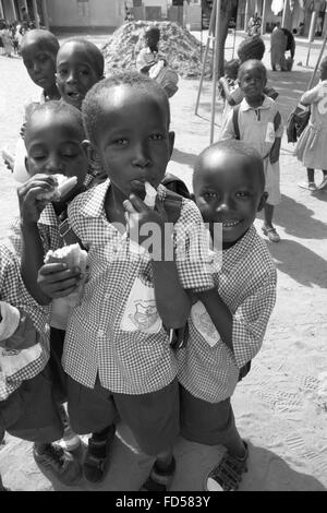 Pause déjeuner pour les enfants en bas noir à un organisme de bienfaisance fonctionner l'école dans les rues de Gambie Kololi Banque D'Images