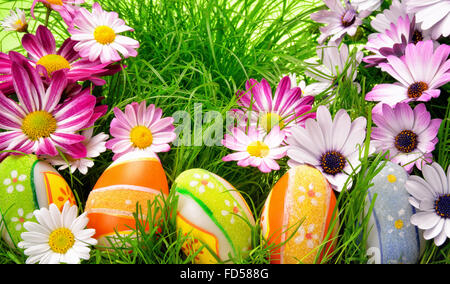Fleurs de Printemps et heureux les oeufs de Pâques colorés sur l'herbe fraîche Banque D'Images