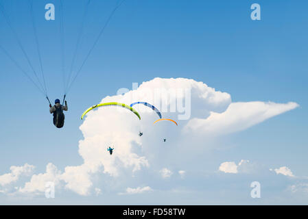 Parapentes quatre dans une rangée en face de nuages et un ciel bleu au lac d'Annecy, France Banque D'Images