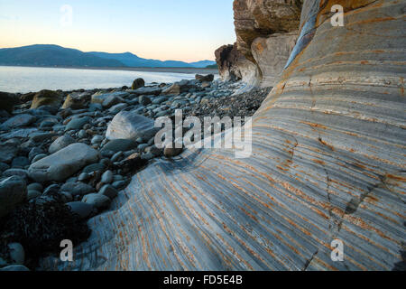 Les petites et grandes roches sont à la base des falaises qui s'élèvent sur le côté sud de l'estuaire à Barmouth bordée de formations rocheuses. Banque D'Images