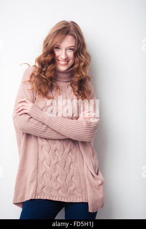 Portrait of a smiling woman standing with arms folded isolé sur fond blanc Banque D'Images