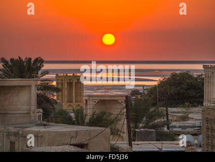 Coucher de soleil sur tours à vent utilisé comme un système de refroidissement naturel dans l'architecture traditionnelle de l'Iran, l'île de Qeshm, Laft, Iran Banque D'Images