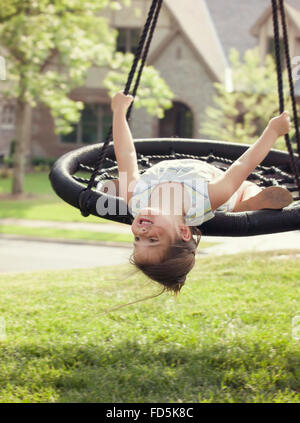 Jeune fille tête en bas de son swing et de sourire. Banque D'Images