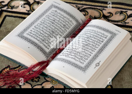 Coran ouvert livre et le chapelet sur un tapis Banque D'Images