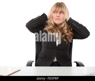 Attractive young businesswoman bloquant ses oreilles dans un effort pour bloquer les bruits indésirables et irritantes, on white Banque D'Images