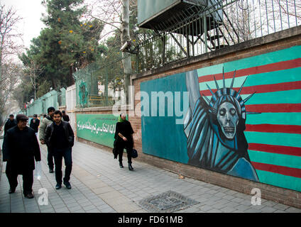 Les personnes de passage en face de fresque anti-américaine propoganda slogan dépeignent statue liberty skeleton sur le mur de l'ancienne ambassade des États-Unis, Central District, Téhéran, Iran Banque D'Images