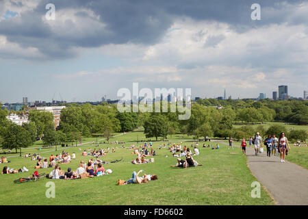 Primrose Hill top avec vue sur la ville de Londres et les gens se détendre dans le parc Banque D'Images