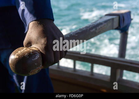 Un pêcheur contrôle le gouvernail sur un bateau de pêche. Banque D'Images