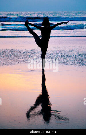 Young woman practicing yoga on beach in Goa, Inde, d'Agonda Banque D'Images