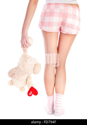 La face arrière de la woman wearing pajamas holding d'ours en peluche avec coeur rouge en main, partie du corps, isolé sur fond blanc Banque D'Images