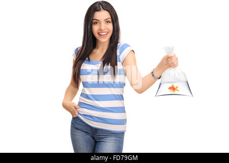 Portrait d'une jeune femme tenant un sac en plastique avec de l'eau et un poisson rouge en elle isolé sur fond blanc Banque D'Images