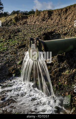 L'eau s'écoule des déchets d'une sortie du tuyau d'eau de déchets dans la rivière dans le Devon UK Banque D'Images