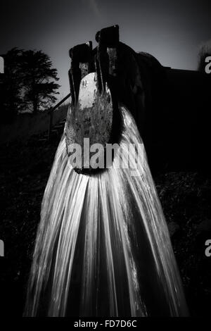 L'eau s'écoule des déchets d'une sortie du tuyau d'eau de déchets dans la rivière dans le Devon UK Banque D'Images