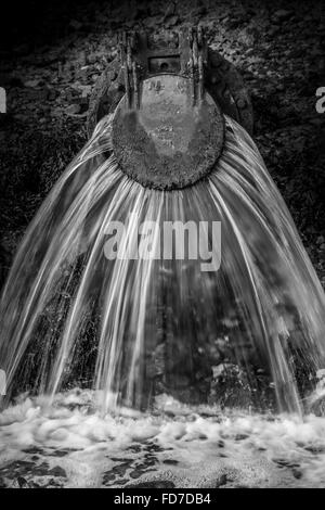 L'eau s'écoule des déchets d'une sortie du tuyau d'eau de déchets dans la rivière dans le Devon UK Banque D'Images