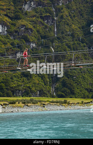 Fille sur le pont suspendu au-dessus de la rivière Matukituki Matukituki Valley, West Branch, près de Wanaka, Otago, île du Sud, Nouvelle-Zélande Banque D'Images