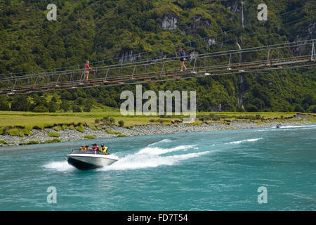 Bateau à réaction et des gens sur pont suspendu au-dessus de la rivière Matukituki Matukituki Valley, West Branch, près de Wanaka, Otago, île du Sud, Banque D'Images