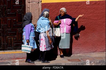 Quatre dames âgées discuter ou aller à côté sur une rue au Mexique. Banque D'Images