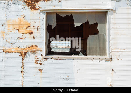 Une fenêtre cassée d'une maison abandonnée à Bombay Beach, en Californie, sur la rive orientale de la mer de Salton Banque D'Images